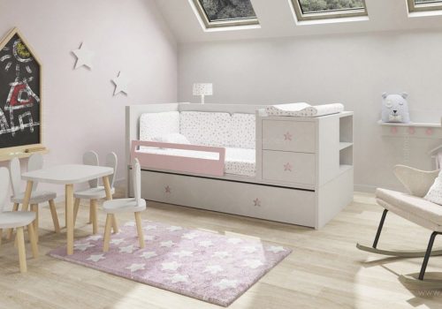 Una acogedora habitación infantil con una combinación de colores blanco y rosa. Cuenta con una cama con ropa de cama con estampado de estrellas y una barandilla lateral de seguridad, una mesa pequeña con sillas, una mecedora y una alfombra con estampado de estrellas. También se ve una pizarra con dibujos y decoraciones de estrellas en las paredes.